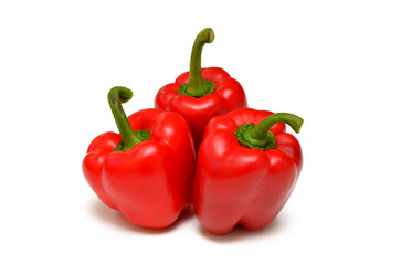 three red sweet peppers isolated on white background