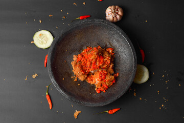 Fried chicken wings with chili sauce on a plate, on a dark background.