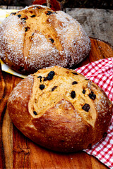 whole round loaves of Irish soda bread baked with sugar crystals encrusted on outside in still life on wood cutting board with checked cloth