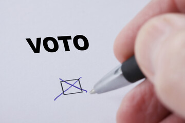 Voto (vote in portuguese)  - hand of man sets mark in check box with pen - hand and pen blurred