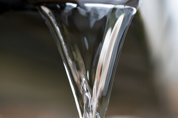 Water flowing out of a gutter drain pipe after a rain storm where the heavens opened up showing the absolute beauty in nature of each individual droplet 