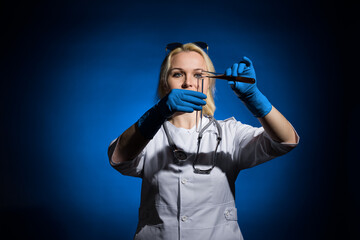 A female doctor in a white coat and gloves pours blood into a test tube on a dark background, hard light. The concept of laboratory research under sanctions.