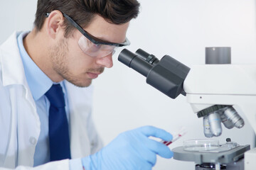 Identifying microorganisms that are causing infection. Cropped shot of a young male scientist...