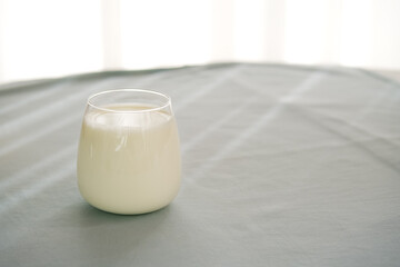 Glass of milk on the table with blue background.