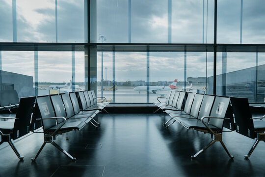 Empty airport terminal lounge with airplane on background. Closed airport
