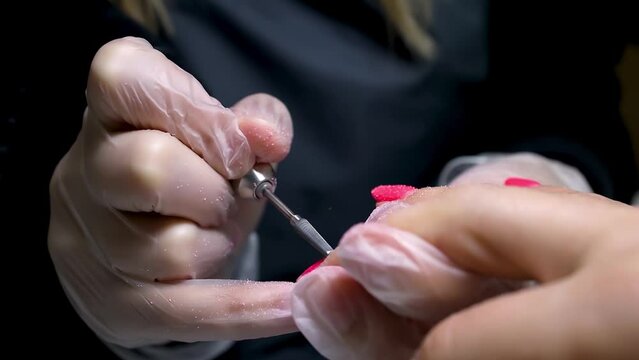 the manicure and pedicure master removes the old nail polish with a manicure machine for milling