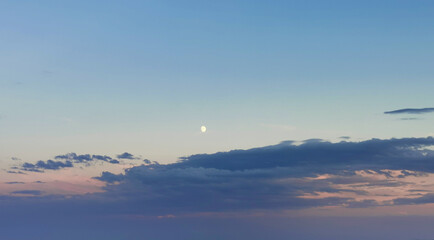 Luna del pomeriggio sopra le nuvole