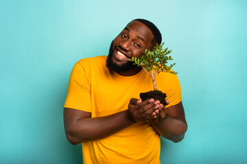 Man holds and takes care of a small tree