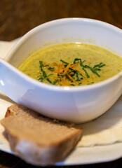 Wild garlic foam soup cream soup in white bowl for restaurant or cafe