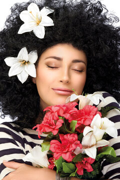 Sensual spring beauty hugging a bouquet of flowers. Beauty portrait in vertical format