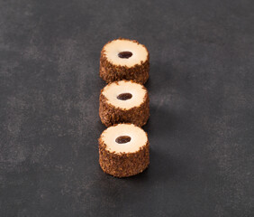 Mousse coffee cakes, in the form of round sushi. Dark background