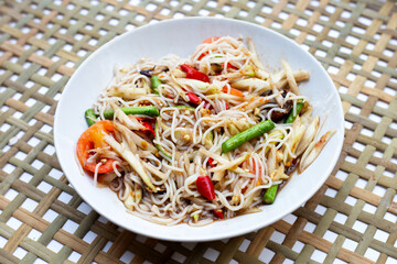 Spicy green papaya salad with vermicelli on white