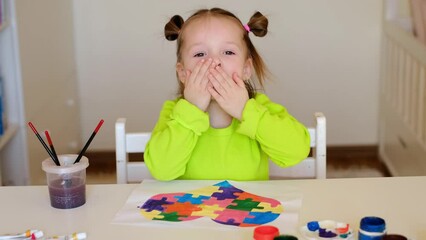The child drew a drawing in support of children with autism and sends kisses and gently hugs everyone and supports. Drawing of a heart with colored puzzles as a symbol of autism. Autism awareness day - Powered by Adobe