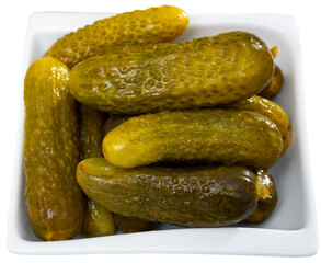 Little pickled cucumbers gherkins on plate, homemade pickles. Isolated over white background