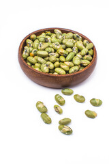 salted bean seeds in a wooden bowl. Isolated on white background.