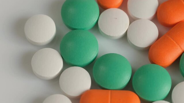 Slow Motion Shot of rotation Colorful Pills on wite Background. 4K