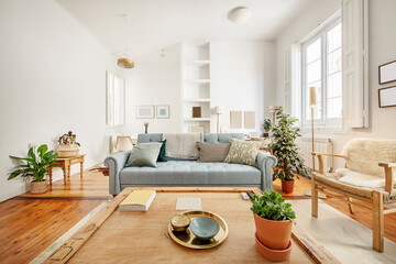 living room with white walls and vintage wooden furniture with plants and decorative lamps in a short-term rental apartment