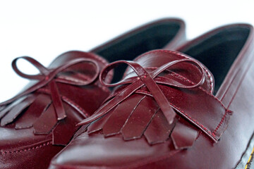 Maroon tassel shoes with rubber soles handcrafted by local craftsmen, photographed on a white background