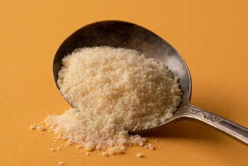 Grated Parmesan Cheese Spilled from a Vintage Spoon