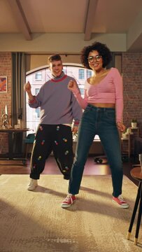 Vertical Screen: Beautiful Stylish Multiethnic Couple in Comfy Home Clothes Dancing and Enjoy Life at Home in Loft Apartment. Recording Funny Viral and Active Videos for Social Media.
