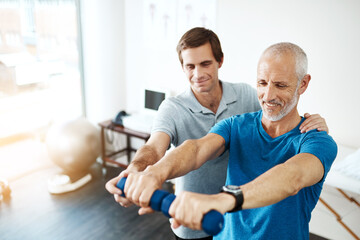 Obraz premium Just a few seconds more. Shot of a young male physiotherapist helping a client with stretching exercises in his office during the day.