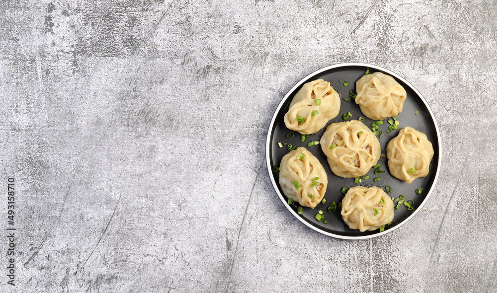 Wall mural manti - asian steam meat dumplings on a round plate on a dark grey background. top view, flat lay