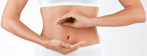 A healthy gut requires a balanced diet. Shot of a woman holding her hands in a circular shape in front of her stomach against a studio background.