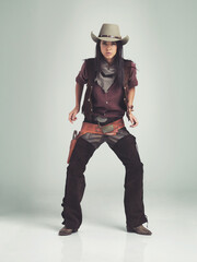 Im the sheriff around these parts.... Full-length shot of an attractive young woman in cowboy...