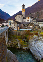 Fototapeta na wymiar Small picturesque village of Lavertezzo in canton of Ticino in Switzerland in Verzasca river valley surrounded by Alps on sunny winter day. View of residential area with ancient parish church