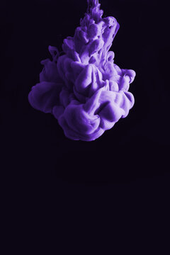 Purple ink drop in clear water and black background. abstract image for background or color reference.
