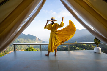 Asian female tourist in beautiful yellow dress, beautiful sky and mountains of nature, Chiang Rai, Thailand.