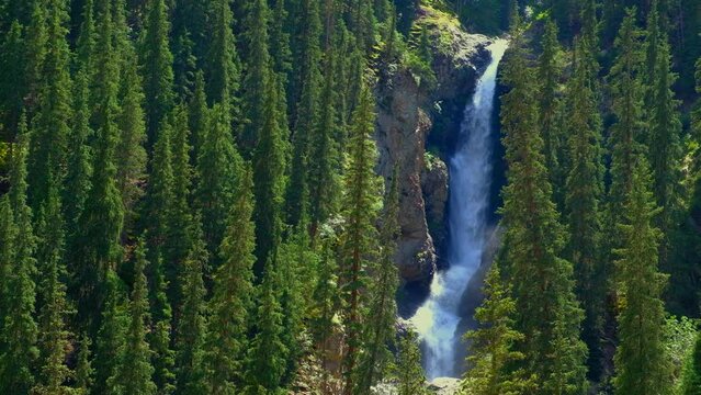 Beautiful waterfall in mountains with. Barskoon waterfall - splashes of Champaign. Travel, tourism in Kyrgyzstan concept. Scenic background.