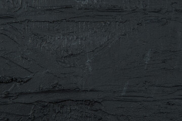 abstract background: black textured plaster, close