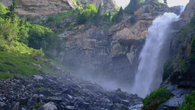 Beautiful waterfall in mountains with. Barskoon waterfall - splashes of Champaign. Travel, tourism in Kyrgyzstan concept. Scenic background.