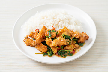 stir-fried fried fish with basil and chili in thai style topped on rice