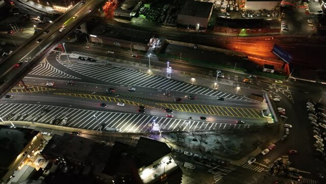 An aerial view of the entrance of the Midtown Tunnel in New York at night. The drone camera tilted down, truck left along the Long Island Expressway on the Queens side of the river.