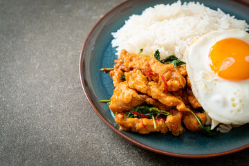 stir-fried fried fish with basil and fried egg topped on rice