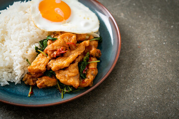 stir-fried fried fish with basil and fried egg topped on rice