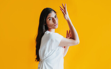 portrait of young latin woman with mexican dress and copy space on yellow background in Latin America	
