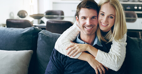 Happy at home. Cropped portrait of an affectionate young couple sitting on their sofa at home.