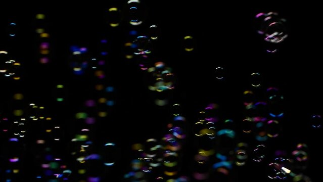 Slow motion of soap water bubbles texture flying over black abstract background