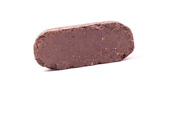 white background. the briquette is dark in color. an alternative type of fuel for heating. close-up.