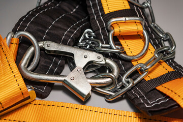 Safety belt for work at height with carabiner. Professional safety equipment for mountaineering and construction. Safety precautions. Close-up.