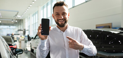 Fototapeta premium charismatic friendly shawarma manager of a car dealership demonstrates the screen of a smartphone