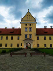 Fototapeta na wymiar Zhovkva Castle is an architectural monument of the Renaissance in the city of Zhovkva in Lviv region of Ukraine. view of the main gate to renaissance castle on cloudy summer day