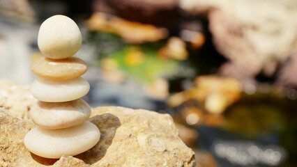 The Balance Stones are stacked as pyramids in a soft natural bokeh background, representing the calm philosophical concept of Jainism's wellness.