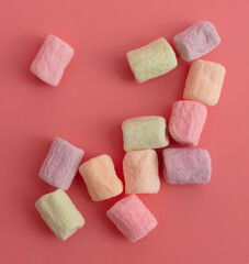 Multicolored candies on a pink background. Close-up
