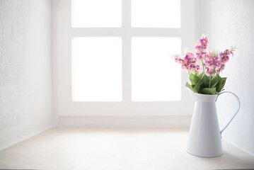 Fototapeta na wymiar Spring flowers in white vase on windowsill