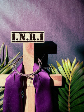 INRI text written on top of wooden cross in purple vintage background. Lent Season,Holy Week and Good Friday concepts. Stock photo.
