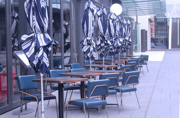 A restaurants's blue outdoor seating area early in the morning. Pictured are tables, chairs and umbrellas. Sydney